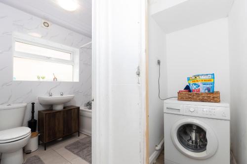 a bathroom with a washing machine and a sink at Bright & Comfortable 2-Bed Home 5 mins from Newcastle City Centre - Free Parking in Gateshead