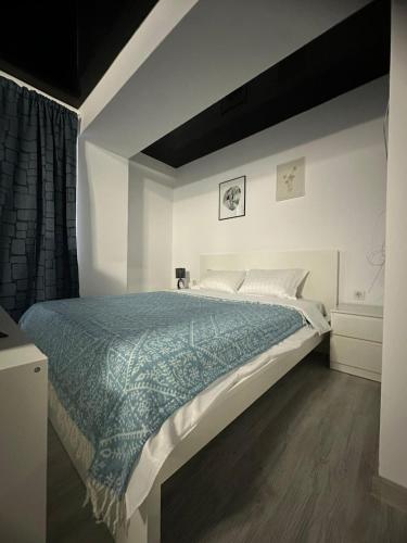 a bedroom with a large bed with a blue comforter at Tower Apartments A6 in Năvodari