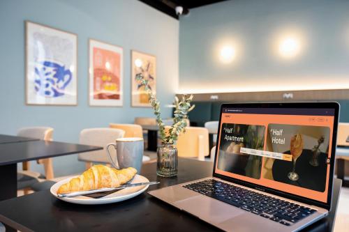 a laptop computer sitting on a table with a plate of food at Staycity Aparthotels Dublin City Quay in Dublin