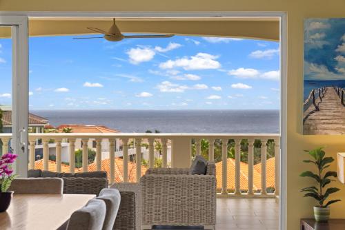a dining room with a view of the ocean at Blue Bay Apartments in Dorp Sint Michiel