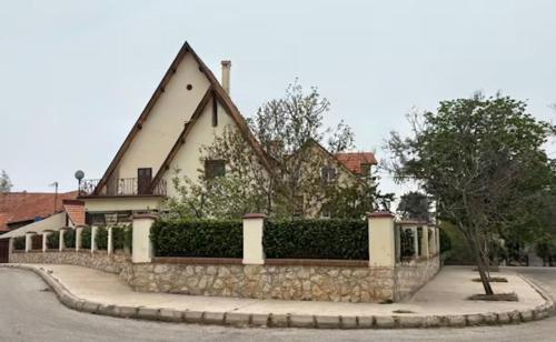 a house with a stone fence in front of a street at Appartement Les Rosiers in Ifrane