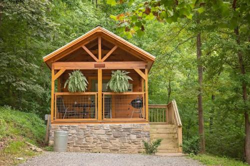 a small building in the middle of a forest at Nana Cabin Tiny Log Home Comfort In Rustic Bliss in Chattanooga