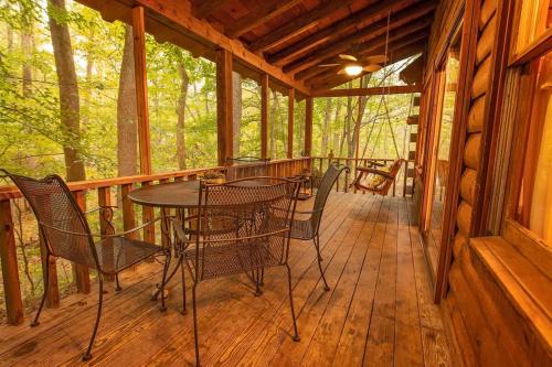 a porch of a cabin with a table and chairs at Creek Crest Cabin Ocoee Riverside Cabin in Ocoee
