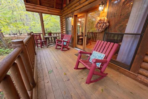 a porch with red rocking chairs on a cabin at Ocoee Cabin Beautiful Cabin On The River's Edge in Ocoee