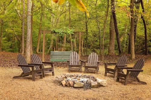 a group of three chairs around a fire pit at The Pines Riverside Log Cabin On The Ocoee in Ocoee