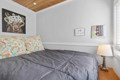 a bedroom with a bed and a picture of a cow at Quail Run Farm- Rustic Tiny Home 1 in Chattanooga