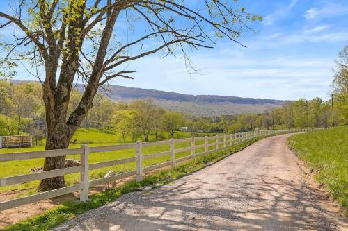 a dirt road next to a fence with a tree at Quail Run Farm- Rustic Tiny Home 1 in Chattanooga