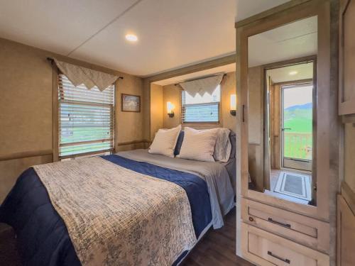 a bedroom in an rv with a bed and windows at Quail Run Farm- Rustic Tiny Home 3 in Chattanooga