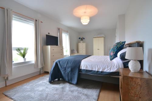 a bedroom with a bed and a television and a window at An Grianán Getaway in Burt