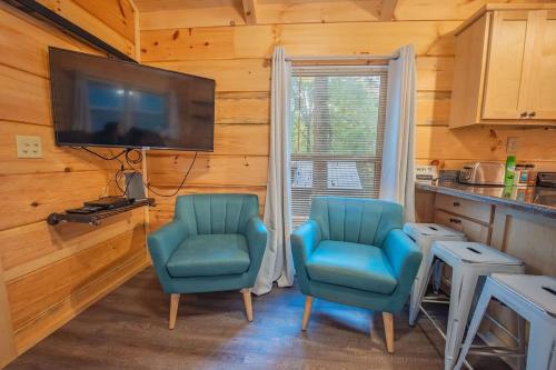 two blue chairs in a kitchen with a tv at Tiny Cabin Village Private Hot Tub Lynda Cabin in Chattanooga