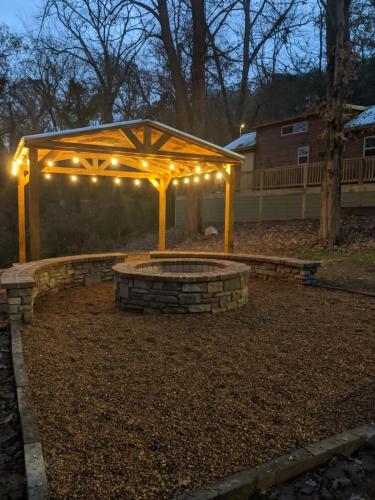 a pergola with lights in a yard at night at Tiny Cabin Village Private Hot Tub Lynda Cabin in Chattanooga