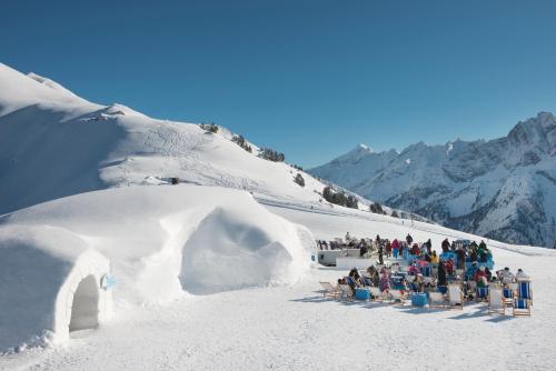 a group of people sitting in the snow next to an ice cave at Landhaus zum Griena in Mayrhofen