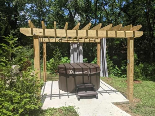a wooden pergola with a trash can under it at Lookout Tiny Cabin 5 Min To Downtown Chattanooga in Chattanooga