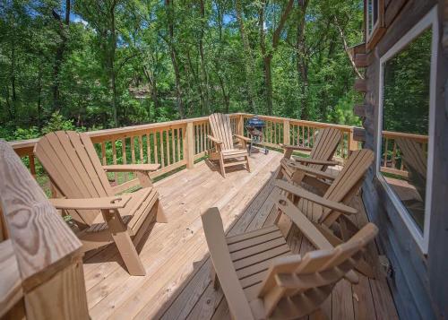 a wooden deck with chairs and a grill on it at Lookout Tiny Cabin 5 Min To Downtown Chattanooga in Chattanooga