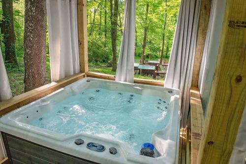 a jacuzzi tub in front of a window at Stefan Cabin Nature-nested Tiny Home Hot Tub in Chattanooga