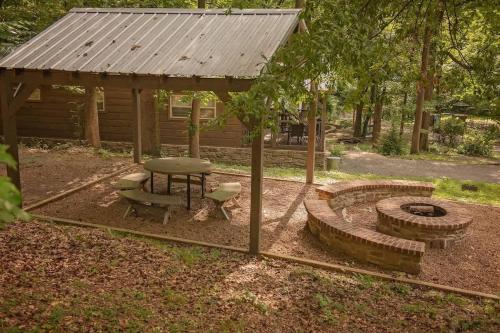 a picnic shelter with a picnic table and a fire pit at Jake Cabin Luxury Hot Tub Cabin Near Downtown in Chattanooga