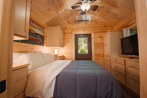 a bedroom with a bed in a wooden cabin at Ernie Cabin Wauhatchie Woodlands Tiny Cabin in Chattanooga