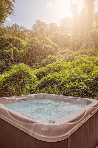 a hot tub in the middle of a forest at Ernie Cabin Wauhatchie Woodlands Tiny Cabin in Chattanooga