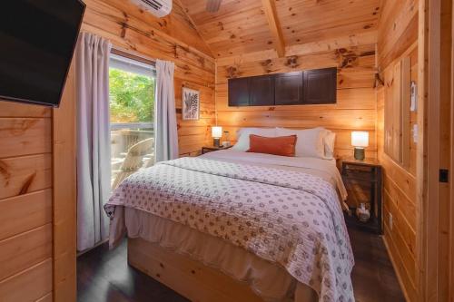 a bedroom with a bed in a wooden cabin at Elise Cabin Forest Retreat 5 Mins To Downtown in Chattanooga