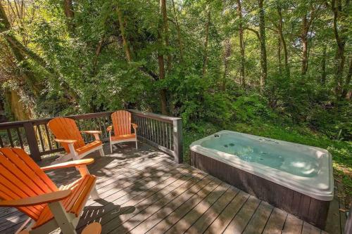 a hot tub sitting on a deck with two chairs at Thomas Cabin Forest Tiny Cabin With Hot Tub in Chattanooga