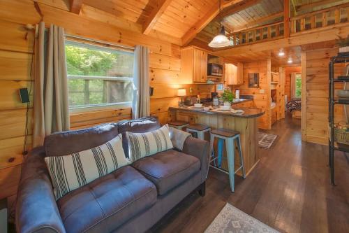 a living room with a couch in a log cabin at Thomas Cabin Forest Tiny Cabin With Hot Tub in Chattanooga
