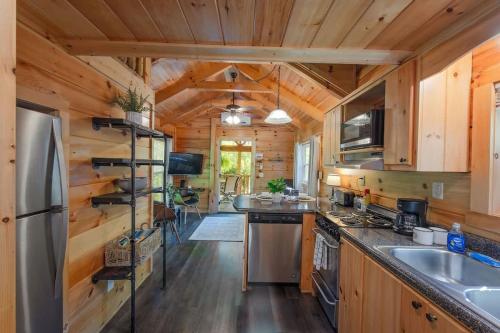 a large kitchen with wooden walls and wooden flooring at Thomas Cabin Forest Tiny Cabin With Hot Tub in Chattanooga