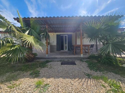 a house with a blue door and some palm trees at Podere Al Covo - House, Garden & Vineyard - Alghero in Alghero