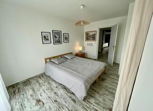 a bedroom with a bed in a white room at Aux Chti Bains in Balaruc-le-Vieux