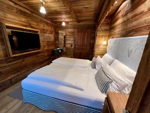 a bedroom with a bed in a wooden cabin at Luxus Chalet in Oberstaufen inkl Wellness Pool und Bergbahnen in Oberstaufen