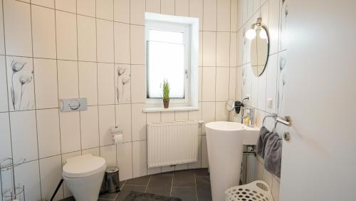 ein weißes Badezimmer mit Waschbecken und Toilette in der Unterkunft Topfit Leisure Park Freinberg Country Suites und Lodges in Freinberg