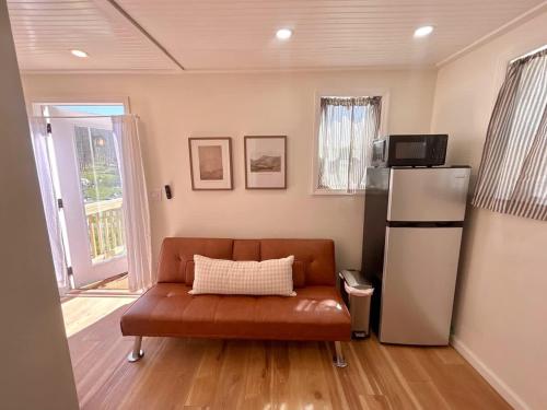 a living room with a couch and a refrigerator at Quail Run Farm- Rustic Tiny Home 2 in Chattanooga