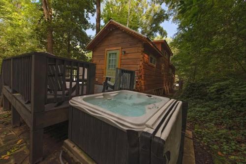 a wooden cabin with a hot tub in front of it at Papa Cabin Tiny Log Home Comfort In Rustic Bliss in Chattanooga