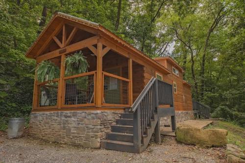 a cabin in the woods with a large window at Papa Cabin Tiny Log Home Comfort In Rustic Bliss in Chattanooga