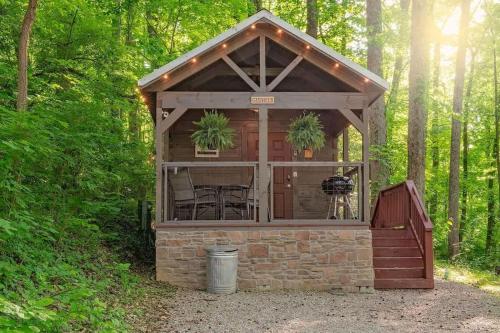 a gazebo with potted plants in the forest at Martha Cabin Tiny Cabin By Downtown Chattanooga in Chattanooga