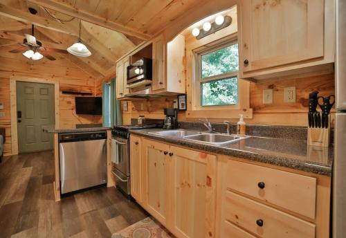 a kitchen with wooden cabinets and a sink at Bryce Cabin Lookout Mtn Tiny Home W Swim Spa in Chattanooga