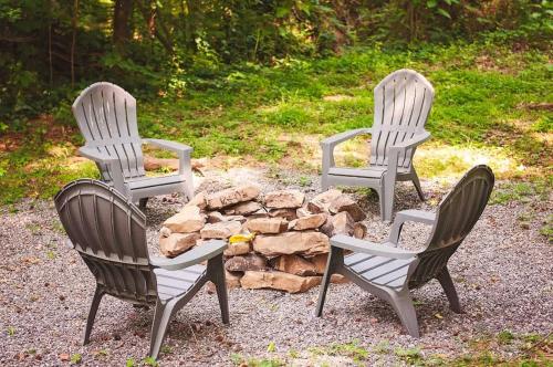 a group of three chairs around a fire pit at Bryce Cabin Lookout Mtn Tiny Home W Swim Spa in Chattanooga