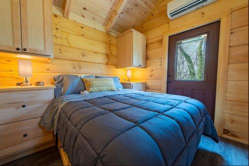 a bedroom with a bed in a log cabin at Meg Cabin Tiny Rustic Comfort On Lookout Mtn in Chattanooga