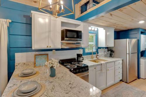 a kitchen with blue walls and white cabinets and a counter at Pops Cabin Lookout Mountain Luxury Tiny Home in Chattanooga