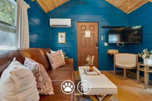 a living room with blue walls and a brown leather couch at Pops Cabin Lookout Mountain Luxury Tiny Home in Chattanooga