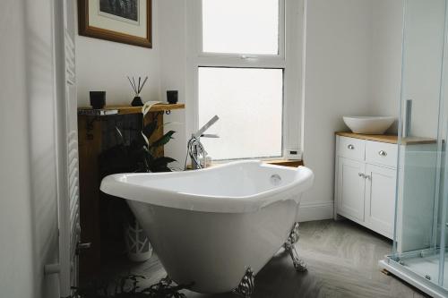 a white bath tub in a bathroom with a window at Sunrise Properties in Barnstaple