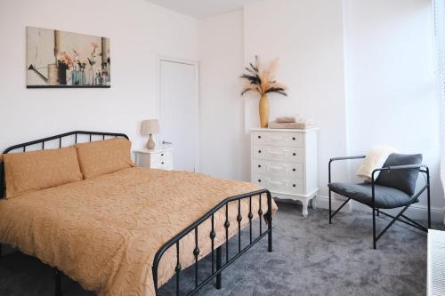 a bedroom with a bed and a chair and a dresser at Sunrise Properties in Barnstaple