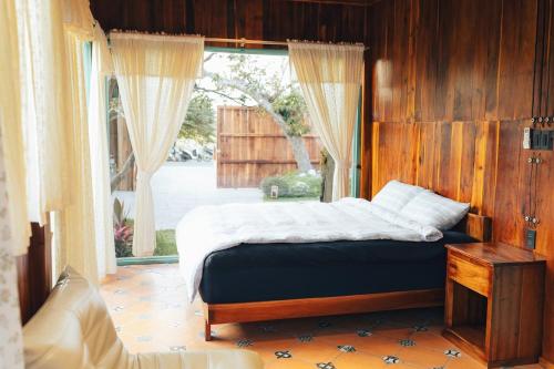 a bedroom with a bed and a large window at Đàng Trong Home 2 in Xóm Rạch Rô