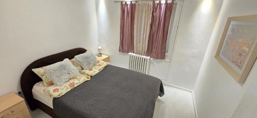 a small bedroom with a bed and a window at Urban Pool & Relax Apartment in Sarajevo