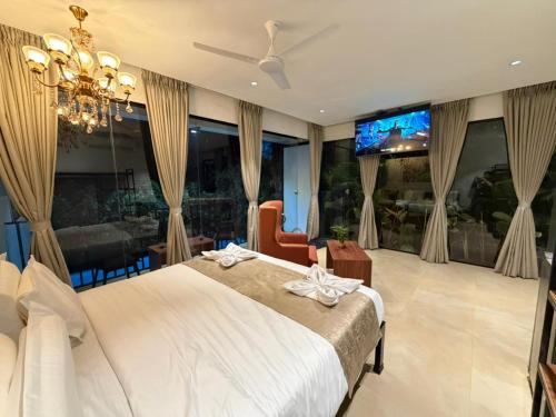 a bedroom with a large bed with a ceiling fan at 7 Tree Resort & Restaurant in Pune