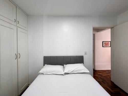 a bedroom with a large white bed and cabinets at Barriga Verde in Florianópolis