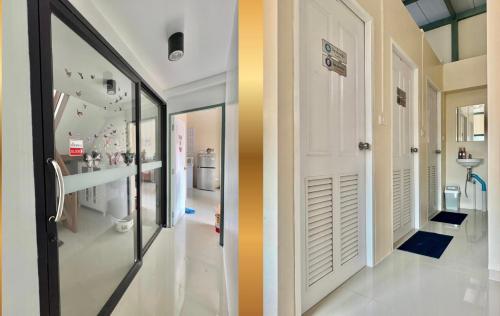 a hallway with a white door and a mirror at TUK&TOON House in Sathani Ban Thap Chang