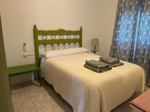a bedroom with a bed with towels on it at Casa Rural Tazgona in Antequera