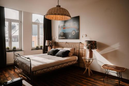 a bedroom with a bed and a picture of a bus on the wall at Cé La Vie in Maaseik