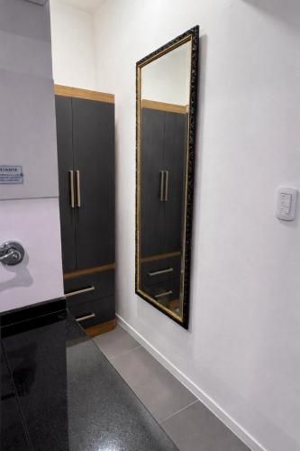 a mirror on a wall next to a bathroom at AGNI Suite Centro in Concepción del Uruguay
