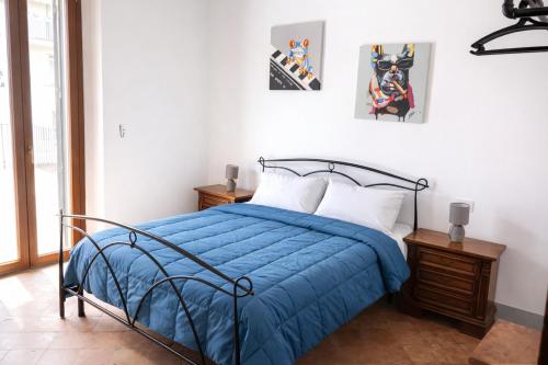 a bedroom with a bed with a blue comforter at 2ª Casa del Borgo Antico in Poggibonsi